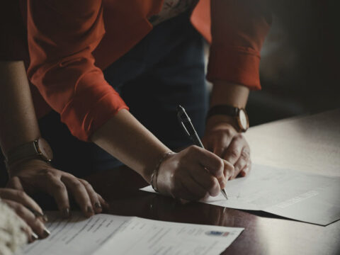 persona firmando documentación en asesoria les corts